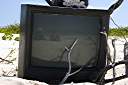 Television, Anegada style.
Nancy found this television on the beach on Anegada's north shore. We dressed it up a bit, making the "rabbit ear" antenna from an oil bottle, some sand and sticks. A nice little coral nick-nack on top, and we are ready to watch television. It turns out that our reflection is the only thing that we can receive on it.