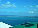 Arriving at Anegada. Boats at Setting Point anchorage visible. Waves breaking over outer reef.