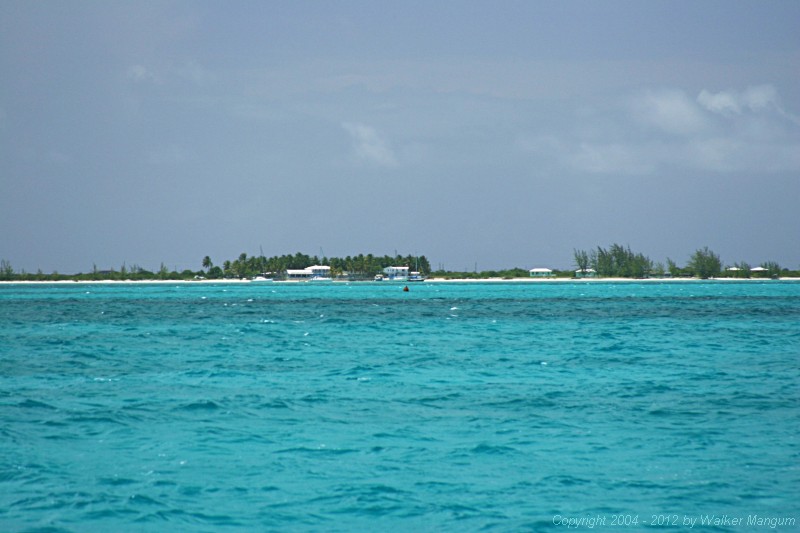 Anegada from one half mile out through a telephoto lens. It is what you would see with a good pair of binoculars. The red entrance buoy is clearly visible below Neptune's Treasure, just below the beach.